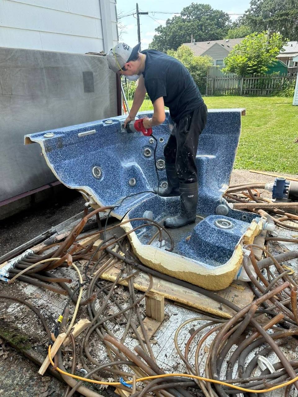 Big Man Little Van owner carefully cutting apart a hot tub